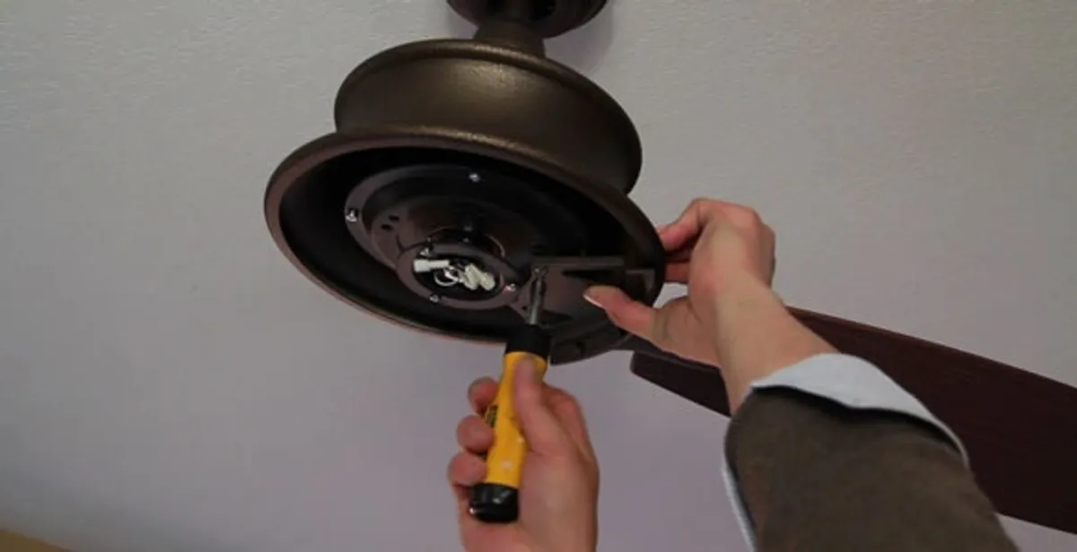 Electrician installing ceiling fan mounting bracket and fixture in Minneapolis, MN