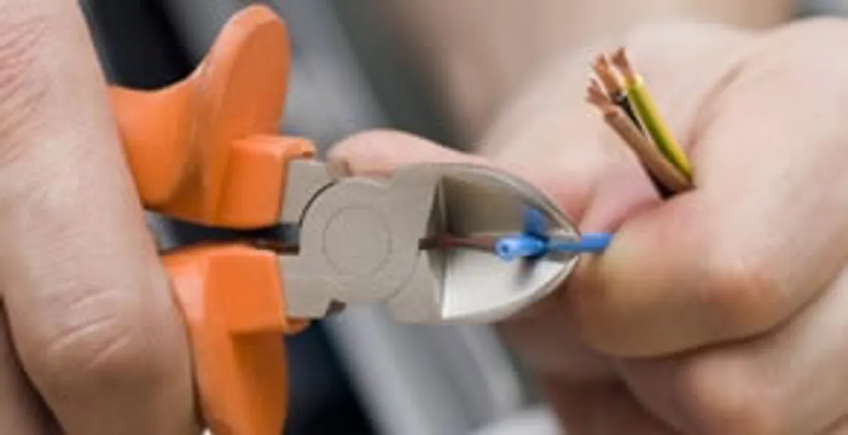 licensed electrician performing precise wire cutting and preparation during electrical service in Minneapolis, MN