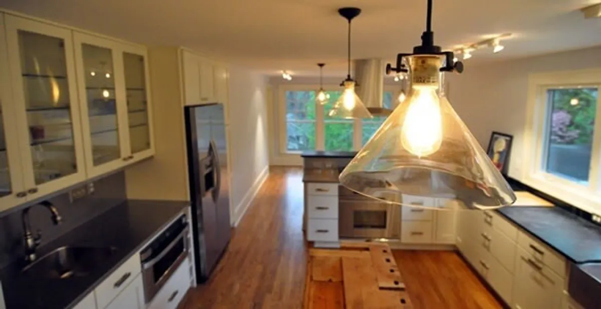 Residential electrician installing modern indoor light fixture in a home in Minneapolis, MN